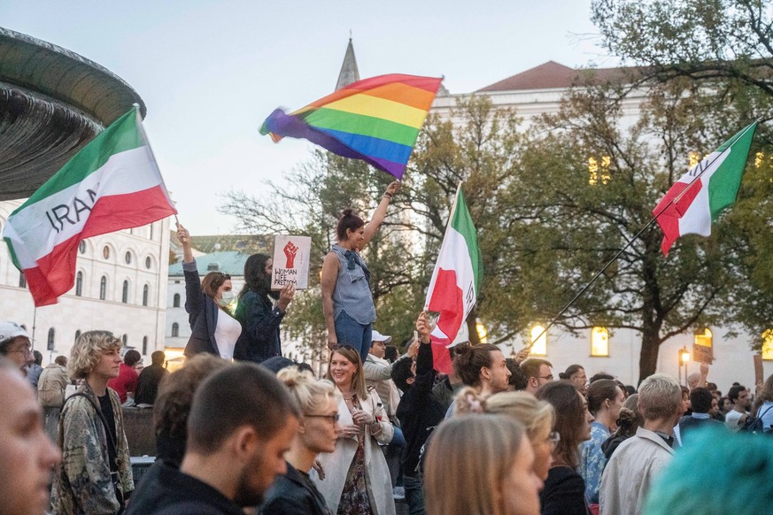 Protest gegen die iranische Führung in München Iranische und Regenbogen Flaggen über der Menge. Am 17. Oktober 2022, versammelten sich hunderte Teilnehmer*innen in München, um ihre Solidarität mit den ...