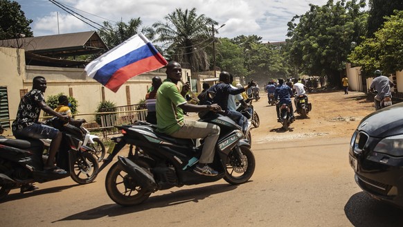 Supporters of Capt. Ibrahim Traore parade waving a Russian flag in the streets of Ouagadougou, Burkina Faso, Sunday, Oct. 2, 2022. Burkina Faso&#039;s new junta leadership is calling for calm after th ...