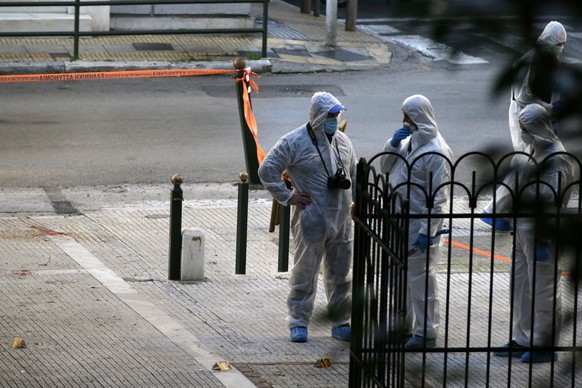 Greek forensic experts search at the scene after an explosion outside the Orthodox church of Agios Dionysios in the upscale Kolonaki area of Athens, Thursday, Dec. 27, 2018. Police in Greece say an of ...