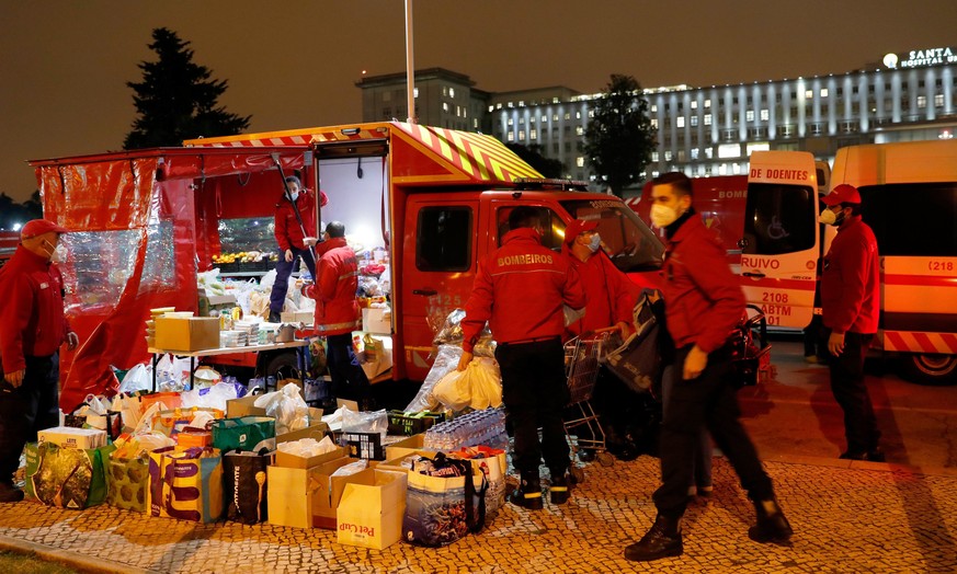 Portugal, Lissabon: Feuerwehrleute organisieren gespendetes Essen für die Krankenwagenbesatzungen, die stundenlang darauf warten, ihre COVID-19-Patienten an die Sanitäter im Santa Maria Krankenhaus zu übergeben.