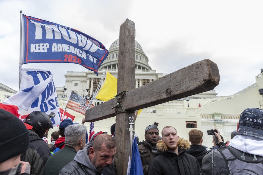 Pro-Trump protester with Christian Cross seen during rally around at Capitol building. Illegal invasion of Capitol building produced four death of protesters, 50 police officers were wounded and lots  ...