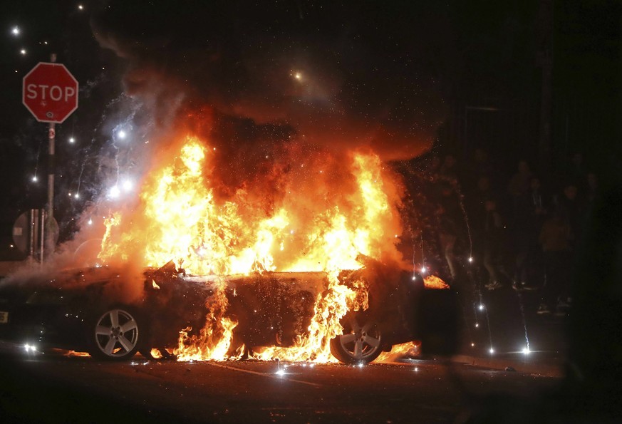 A car burns after petrol bombs were thrown at police in Creggan, Londonderry, in Northern Ireland, Thursday, April 18, 2019. (Niall Carson/PA via AP)