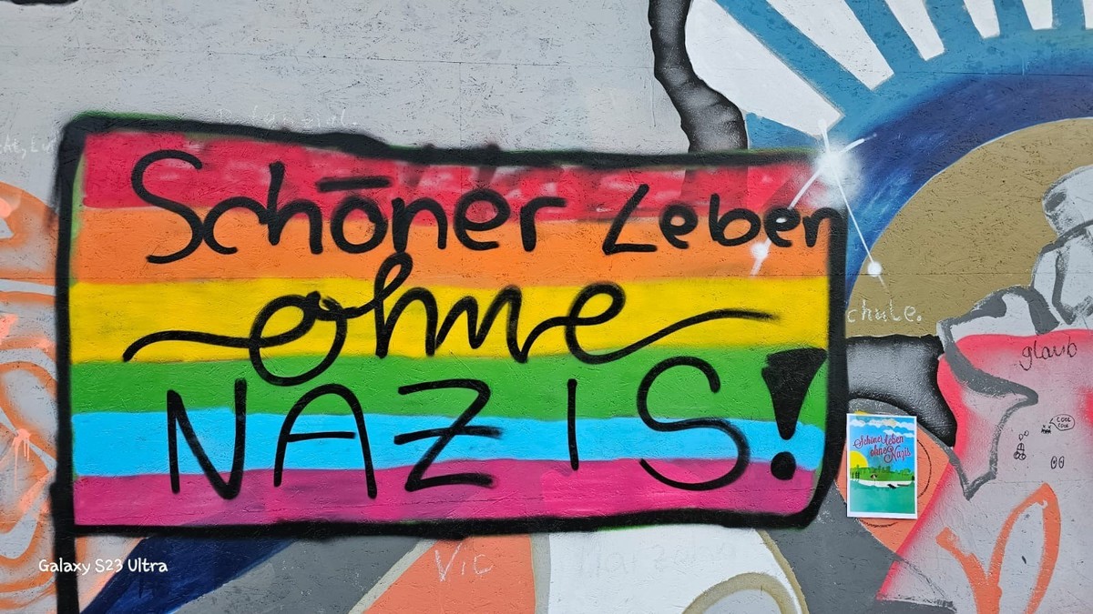 HANDOUT - 03.09.2023, Brandenburg, Eisenh�ttenstadt: Ein undatiertes Handout zeigt die Parole �Sch�ner Leben ohne Nazis!� auf einem bunten Hintergrund, an einer Wand an einer Stelle, an der eine recht ...