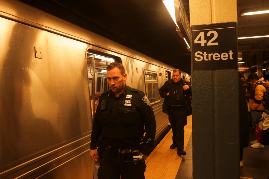 Police and security officers patrol Manhattan subways after a shooting at a subway station in the Brooklyn borough of New York City, New York, U.S., April 12, 2022. REUTERS/Jeenah Moon