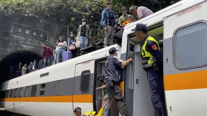Sicherheitskräfte helfen den Menschen aus dem entgleisten Zug in Taiwan.