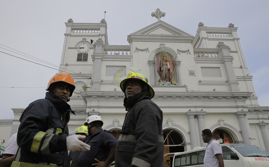 Sri Lankan firefighters stand in the area around St. Anthony's Shrine after a blast in Colombo, Sri Lanka, Sunday, April 21, 2019. A Sri Lanka hospital spokesman says several blasts on Easter Sunday h ...