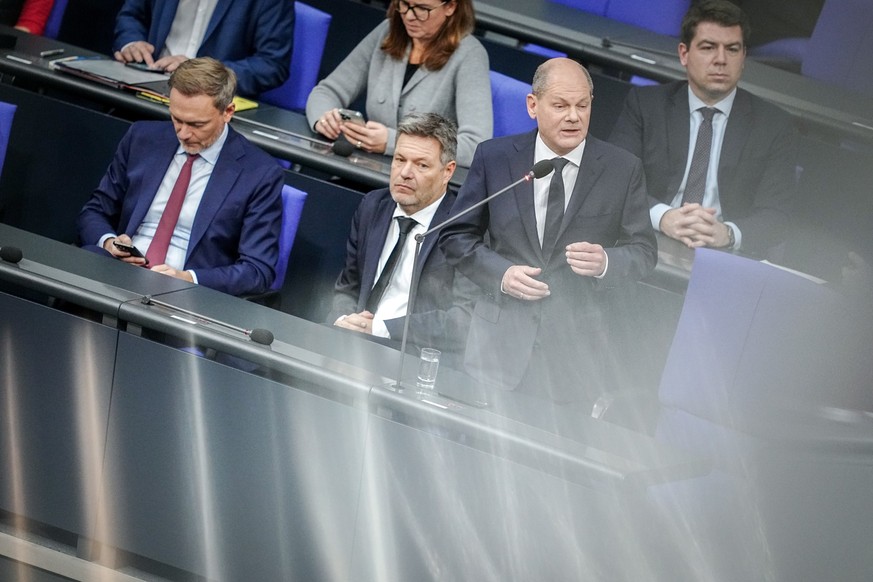 15.11.2023, Berlin: Bundeskanzler Olaf Scholz (SPD) spricht bei der Regierungsbefragung im Bundestag neben Christian Lindner (l, FDP), Bundesminister der Finanzen, und Robert Habeck (M, Bündnis 90/Die ...