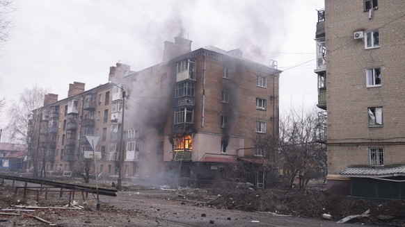 27.02.2023, Ukraine, Bachmut: Rauch steigt von einem brennenden Haus auf. Foto: Yevhen Titov/AP +++ dpa-Bildfunk +++