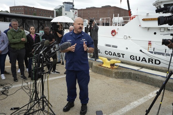 U.S. Coast Guard Capt. Jamie Frederick, center, faces reporters during a news conference, Tuesday, June 20, 2023, at Coast Guard Base Boston, in Boston. The U.S. Coast Guard says a search covering 10, ...