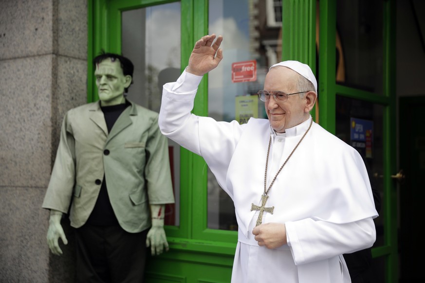 24.08.2018, Irland, Dublin: Eine Wachsfigur von Papst Franziskus steht neben einer Wachsfigur von Frankeinstein vor dem Wachsmuseum in Dublin. Papst Franziskus kommt am kommenden Wochenende nach Irlan ...