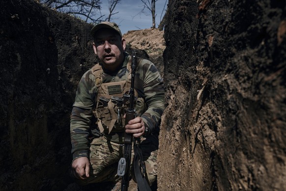 10.04.2023, Ukraine, Bachmut: Ein ukrainischer Soldat geht in einem Graben an der Frontlinie in Bachmut. Die russische Söldnereinheit Wagner hat nach eigenen Angaben weitere Geländegewinne in der seit ...