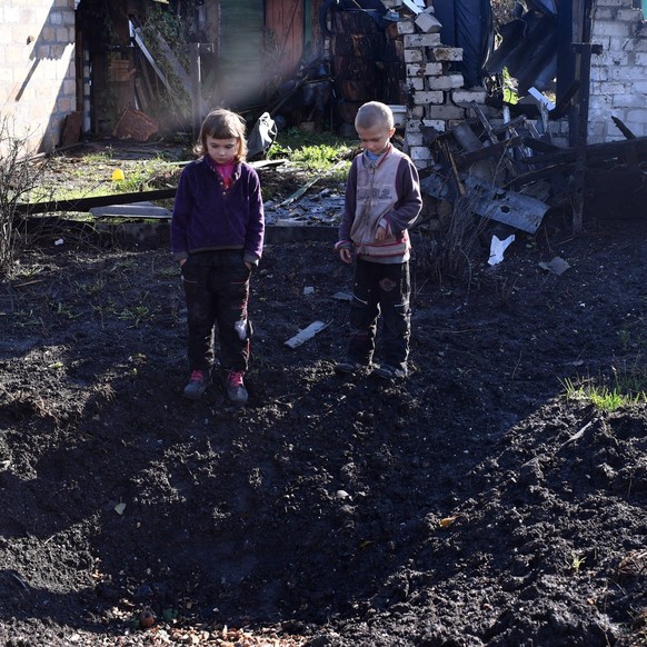 Russia Ukraine Military Operation Shelling 8295264 12.10.2022 Children stand at a shell crater in the village of Shepilovka which is located in the combat zone as Russia s military operation in Ukrain ...