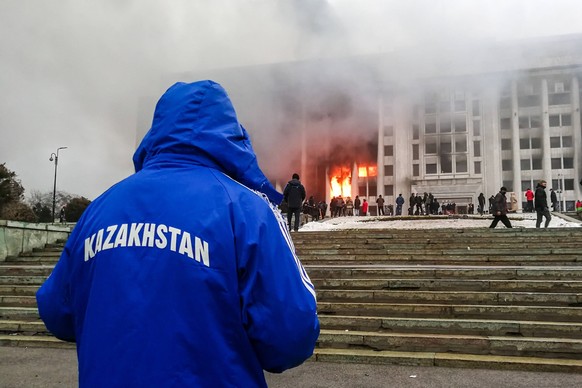 ALMATY, KAZAKHSTAN - JANUARY 5, 2022: People rally outside the burning mayors office. Protests are spreading across Kazakhstan over the rising fuel prices protesters broke into the Almaty mayors offic ...