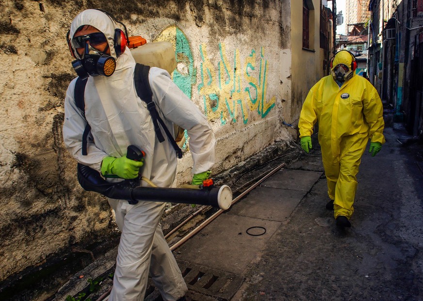 NITEROI, BRAZIL - MARCH 25: Agents of the sanitary department clean streets and alleys of the Vila Ipiranga Favela, in Fonseca neighborhood on March 25, 2020 in Niteroi, Brazil. Vila Ipiranga is the f ...