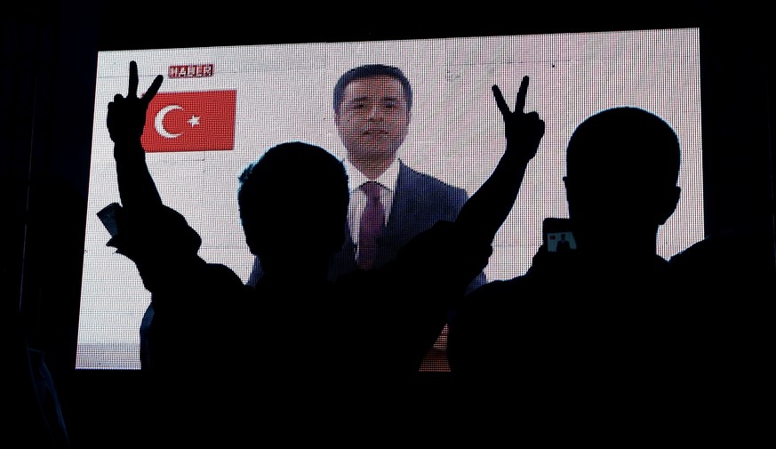 Supporters of Turkey's main pro-Kurdish Peoples' Democratic Party (HDP) watch the jailed former leader and presidential candidate Selahattin Demirtas as his first television appearance in over a year  ...