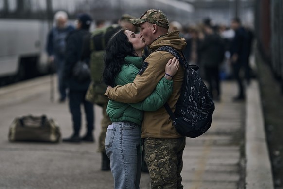 A Ukrainian soldier says goodbye to his wife as she takes a train at a railway station in Kramatorsk, Donetsk region, Ukraine, Tuesday, March 21, 2023. (AP Photo/Libkos)
