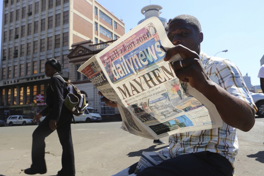 A man reads a newspaper headline in Harare, Zimbabwe,Wednesday, Aug, 2, 2018. Zimbabweans are awaiting the results from a presidential election that they hope will lift the country out of economic and ...