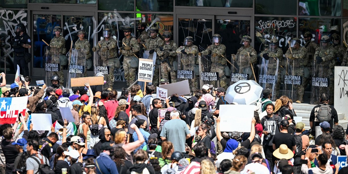 09.06.2025, USA, Los Angeles: Einheiten der Nationalgarde stehen protestierenden Menschen am Federal Building auf der Los Angeles Street in Downtown LA gegenüber. In Los Angeles protestieren Menschen  ...