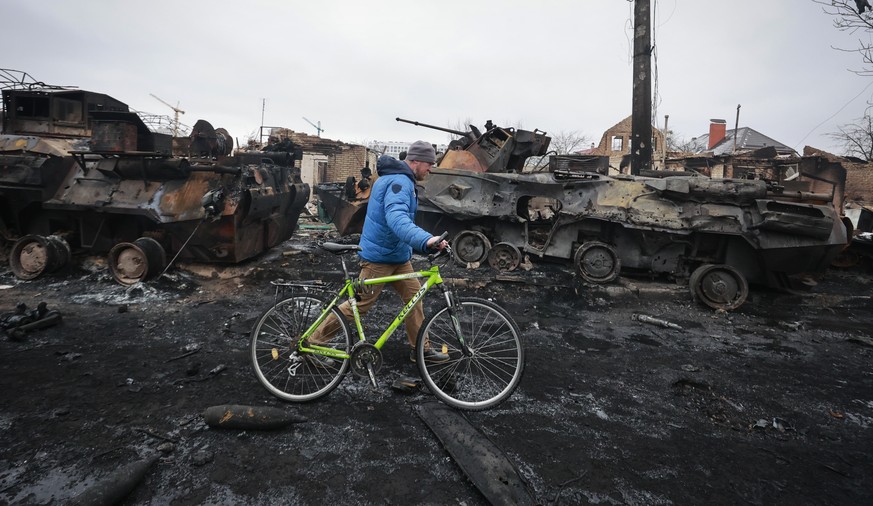 A man walks past the remains of a Russian military vehicles in Bucha, close to the capital Kyiv, Ukraine, Tuesday, March 1, 2022. Russia on Tuesday stepped up shelling of Kharkiv, Ukraine&#039;s secon ...