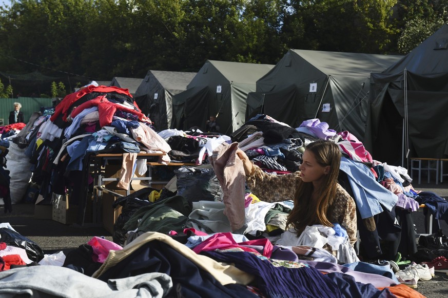 A woman evacuated from a fighting between Russian and Ukrainian forces in Kursk region chooses clothes at a temporary residence center in Kursk, Russia, Monday, Aug. 12, 2024. (AP Photo)