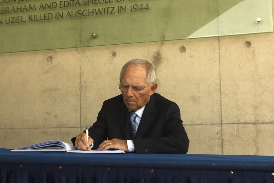 Bundestag President Wolfgang Schaeuble signs a guest book during his visit to the Yad Vashem Holocaust memorial in Jerusalem, Thursday, Oct. 25, 2018. (AP Photo/Sebastian Scheiner)