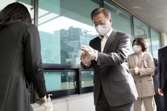 South Korean President Moon Jae-in wearing a mask and a plastic gloves to prevent contracting the coronavirus disease (COVID-19), arrives to cast his absentee ballot at a polling station for parliamen ...