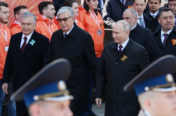 09.05.2023, Russland, Moskau: Der russische Präsident Wladimir Putin (r), der kasachische Präsident Kassym-Schomart Tokajew (M) und der usbekische Präsident Shavkat Mirsijojew (l) kommen zur Militärpa ...