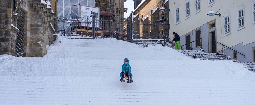 Der Domplatz ist mit einer dicken Schneedecke belegt. Die Domstufen werden zum Rodeln und Skifahren genutzt. Anton 8 ra�t mit dem Schlitten den Domstufen nach unten. Wintersportfreuden auf den Domstuf ...