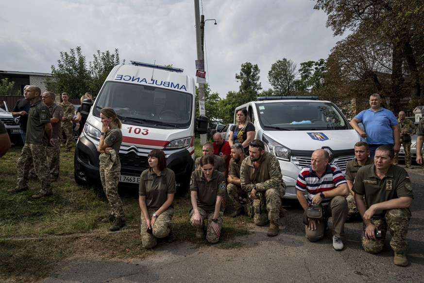 01.09.2023, Ukraine, Poltawa: Ukrainische Soldaten der «18. Fliegerbrigade» knien während der Abschiedszeremonie für gefallene ukrainischen Piloten und Besatzungsmitglieder der «Mi-8-Militärhubschraub ...