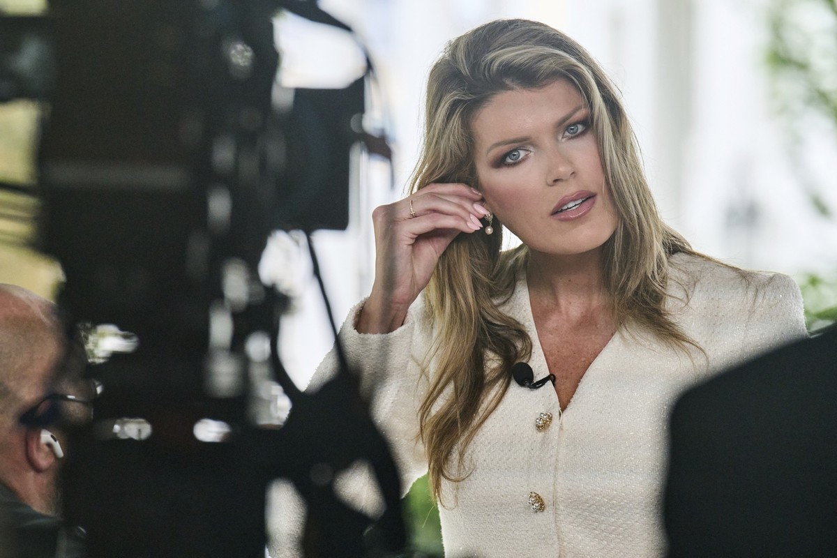 Lindsey Halligan, special assistant to the president, fixes an earring at the end of an interview outside of the White House, Wednesday, Aug. 20, 2025, in Washington. (AP Photo/Jacquelyn Martin)