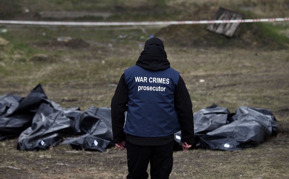 Ein Ermittler trägt eine Weste mit der Aufschrift "War Crimes Prosecutor" ("Ankläger für Kriegsverbrechen"). Er sammelt Beweise für Kriegsverbrechen in Butscha.