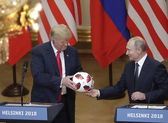 Russian President Vladimir Putin gives a soccer ball to U.S. President Donald Trump during a press conference after their meeting at the Presidential Palace in Helsinki, Finland, Monday, July 16, 2018 ...
