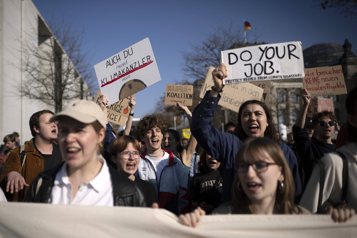 Fridays for Future DEU, Deutschland, Germany, Berlin, 21.03.2025 Demonstranten der Fridays For Future Bewegung vor dem Reichstag mit Schild Auch Du musst Klimakanzler sein mit Symbol Glatze vom Kanzle ...