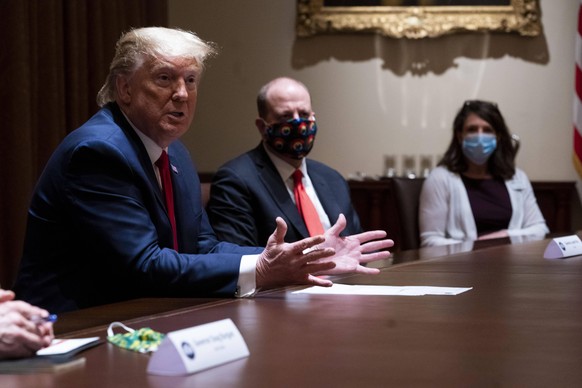 Governor Jared Polis Democrat of Colorado with mask, looks on as United States President Donald J. Trump makes remarks during a meeting with Governor Doug Burgum Republican of North Dakota in the Cabi ...