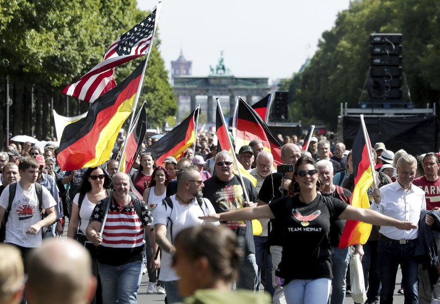 People attend a protest rally in Berlin, Germany, Saturday, Aug. 29, 2020 against new coronavirus restrictions in Germany. Police in Berlin have requested thousands of reinforcements from other parts  ...