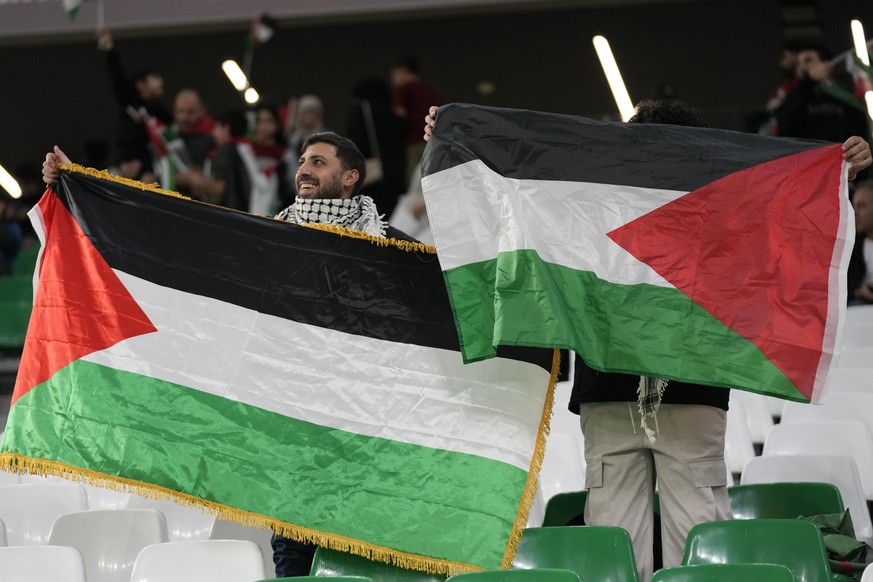 14.01.2024, Katar, Al-Rajjan: Fußball: Asien Cup, Iran - Palästina, Gruppenphase, Gruppe C, 1. Spieltag, Education City Stadium: Fans halten palästinensische Fahnen vor dem Spiel. Foto: Aijaz Rahi/AP/ ...