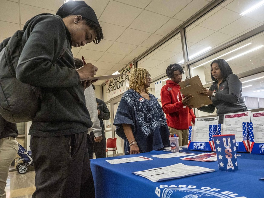 September 17, 2024, Washington, District Of Columbia, USA: KENYATTA PHILSON right from the DC Board of Elections reviews a students voter registration application as other students register to vote. T ...