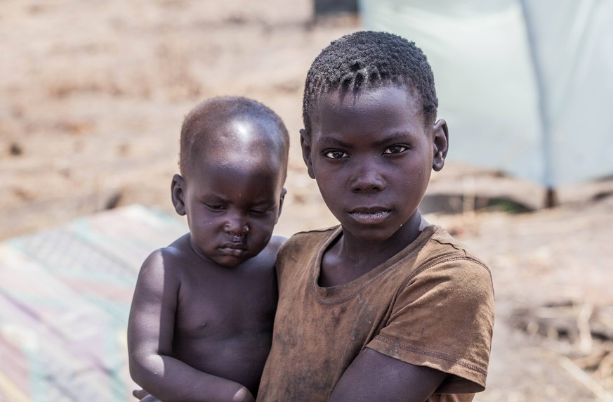 Mass exodus in Central Equatoria - 10/02/2017 - Uganda - A young boy carries his brother in the Palorinya settlement, Moyo district, northern Uganda. Most refugees (86%) fleeing South Sudan are women  ...