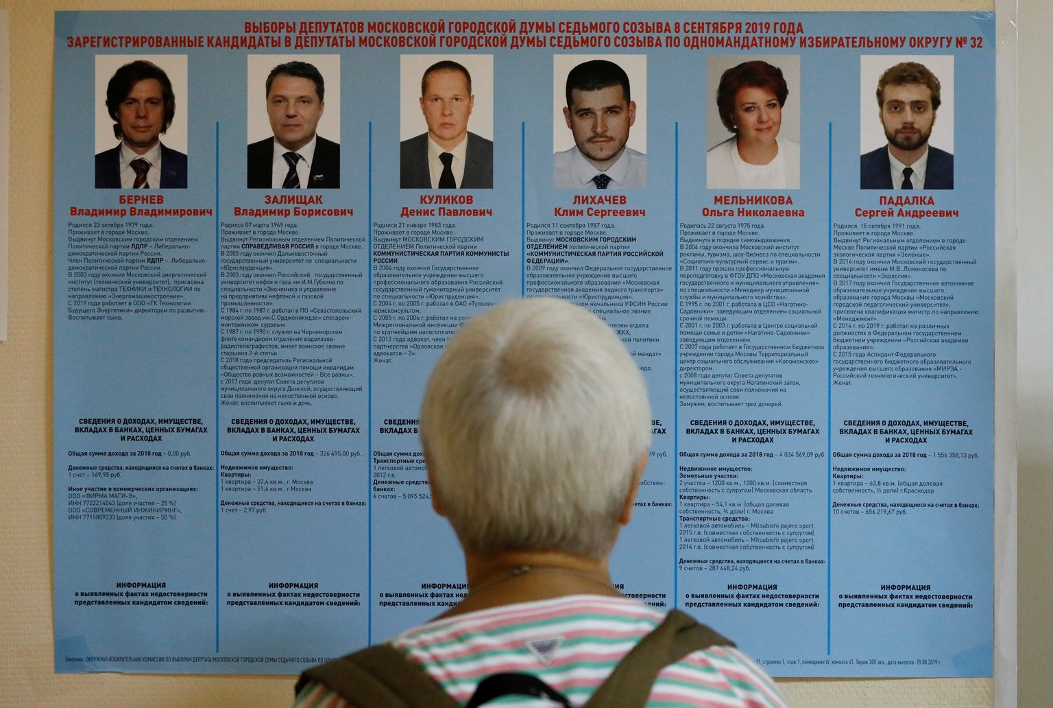A voter studies a candidate information broadsheet at a polling station during the Moscow city parliament election in Moscow, Russia September 8, 2019. REUTERS/Shamil Zhumatov