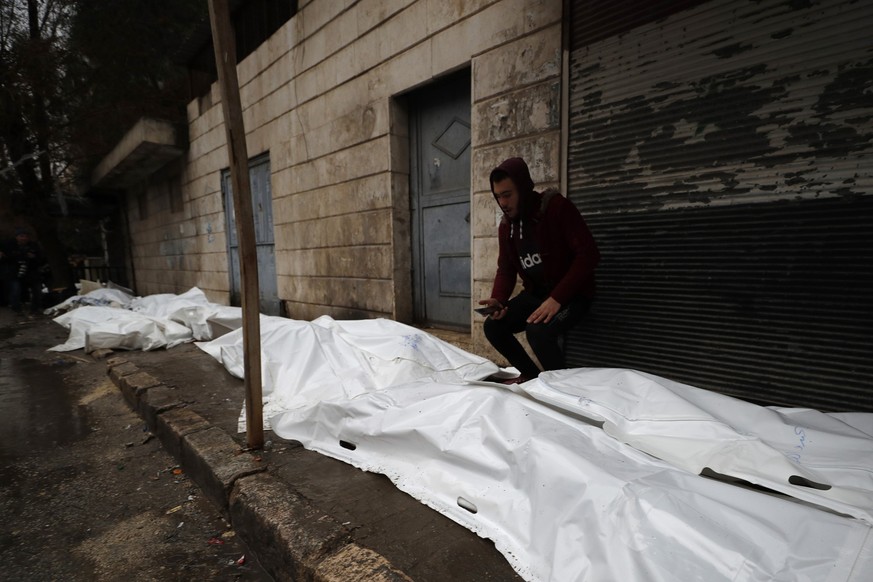 A man tries to identify the bodies of earthquake victims recovered outside a hospital, in Aleppo, Syria, Monday, Feb. 6, 2023. A powerful earthquake rocked wide swaths of Turkey and neighboring Syria  ...