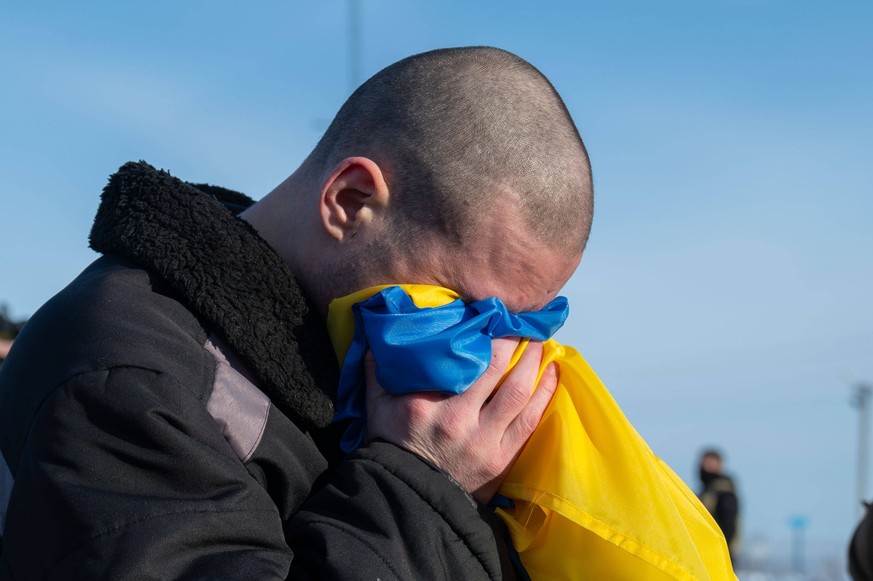 Ukrainian former prisoners of war wrapped in a Ukrainian flag, following a prisoner exchange Ukrainian former prisoners of war wrapped in a Ukrainian flag, following a prisoner exchange, amid Russia s ...