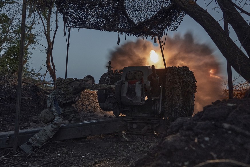 05.07.2023, Ukraine, Bachmut: Ein ukrainischer Soldat der 10. Sturmbrigade Edelweiß feuert die Munition einer D-30-Haubitze auf russische Stellungen an der Frontlinie. Foto: Libkos/AP/dpa +++ dpa-Bild ...