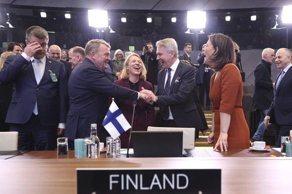 04.04.2023, Belgien, Brüssel: Lars Lokke Rasmussen (M, l), Außenminister von Dänemark, gibt Pekka Haavisto (M, r), Außenminister von Finnland, bei einer Sitzung der Nato-Ukraine-Kommission im Nato-Hau ...