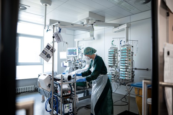 ARCHIV - 23.09.2021, ---: Eine Mitarbeiterin der Pflege steht in einem Zimmer der Corona-Intensivstation Eines Klinikums und bedient ein ECMO-Gerät, eine Herz-Lungen-Maschiene. Der Bundestag stimmt am ...