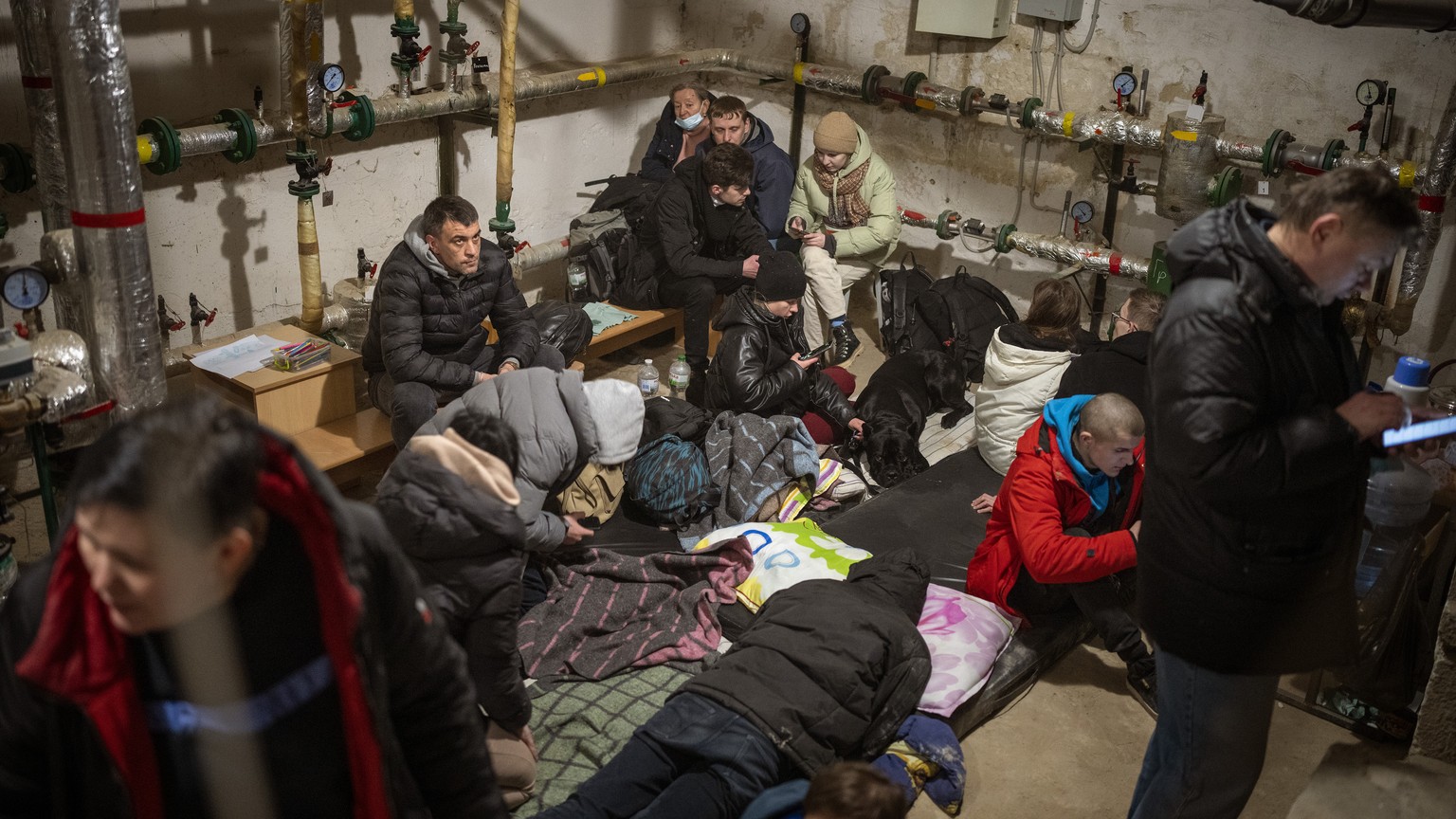 25.02.2022, Ukraine, Kiew: Menschen suchen Schutz in einem Keller eines Geb