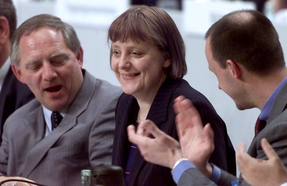 FILE PHOTO: Angela Merkel (C) receives applause by her predeccessor Wolfgang Schaeuble and parliamentary floor leader Friedrich Merz (R) after being elected as the new chairman of the opposition Chris ...