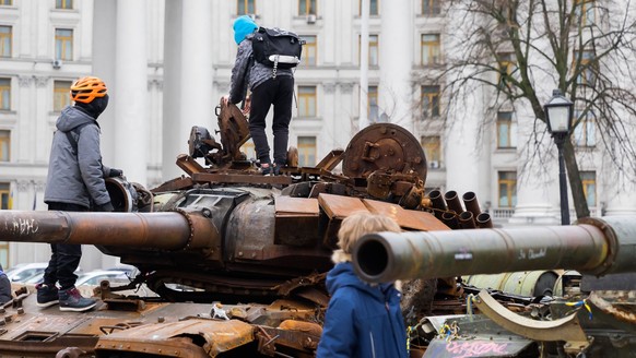04.04.2023, Ukraine, Kiew: Kinder klettern auf einem zerstörten russischen Panzer in der Innenstadt. Bundeswirtschaftsminister Habeck ist mit einer Wirtschaftsdelegation zu Besuch in der Ukraine. Foto ...