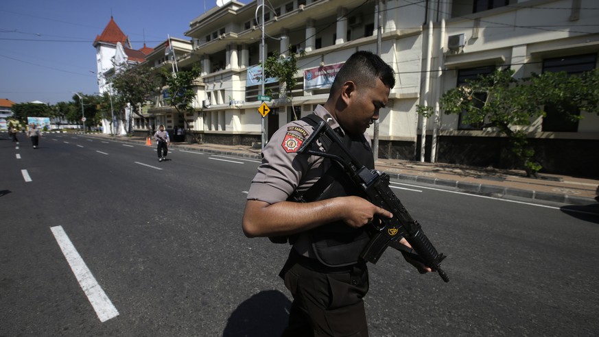 Officers block the road outside a local police headquarters following an attack in Surabaya, East Java, Indonesia, Monday, May 14, 2018. The police headquarters in Indonesia's second largest city was  ...