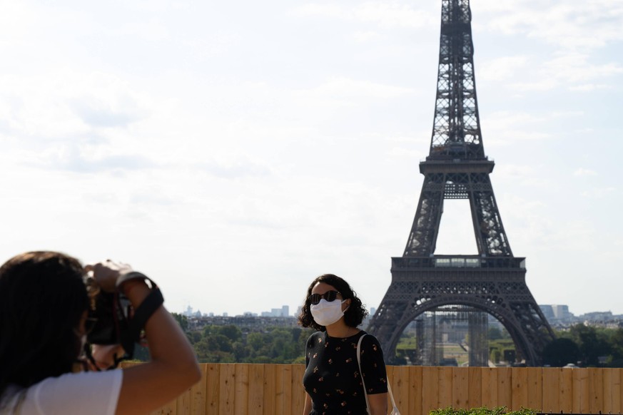 Touristen schießen Fotos vor dem Eifelturm. Das Corona-Virus beherrscht die meisten europäischen Länder nach wie vor.