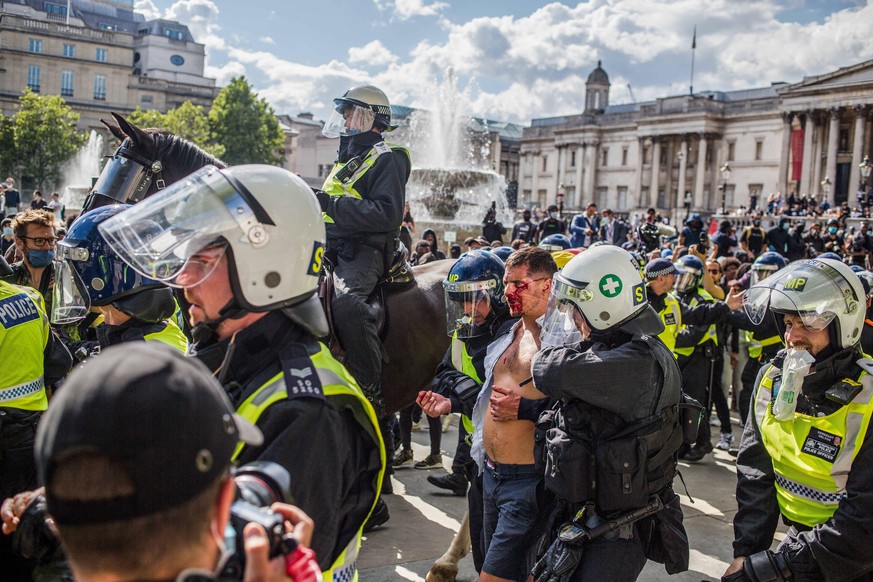 June 13, 2020, London, United Kingdom: EDITORS NOTE: Image contains graphic content.Police officers rescue an EDL supporter who was attacked by the Black lives matter protesters in Trafalgar square du ...